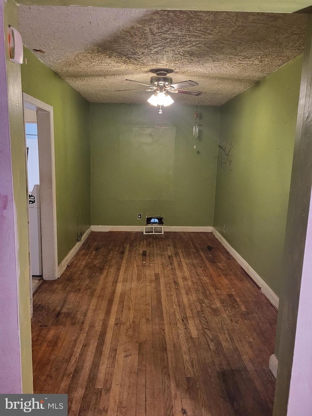 unfurnished room with a textured ceiling, a ceiling fan, hardwood / wood-style flooring, and baseboards