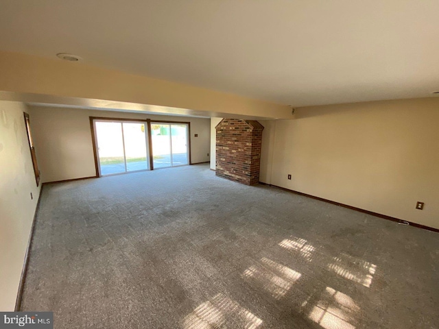 unfurnished living room featuring a brick fireplace and carpet flooring