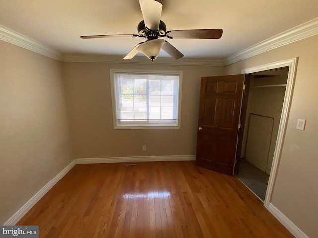 unfurnished bedroom featuring ceiling fan, hardwood / wood-style flooring, a closet, and ornamental molding