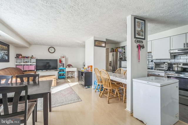 dining area featuring a textured ceiling and light wood-type flooring