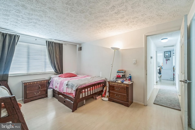 bedroom featuring light hardwood / wood-style flooring and a textured ceiling