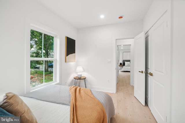 bedroom with light hardwood / wood-style flooring and multiple windows