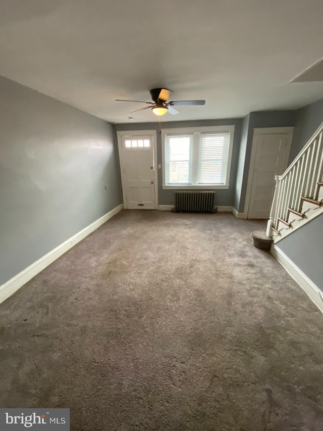 carpeted entrance foyer featuring radiator heating unit and ceiling fan