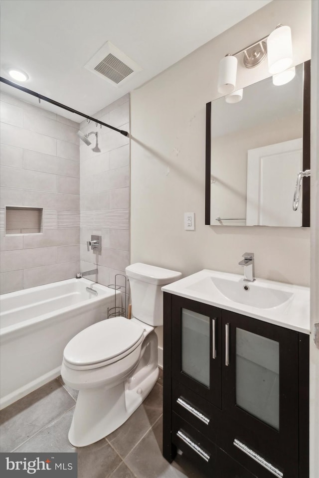 full bathroom featuring toilet, tiled shower / bath, vanity, and tile patterned floors