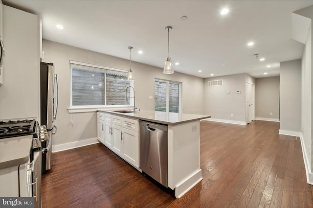 kitchen featuring dark hardwood / wood-style floors, sink, decorative light fixtures, white cabinetry, and appliances with stainless steel finishes