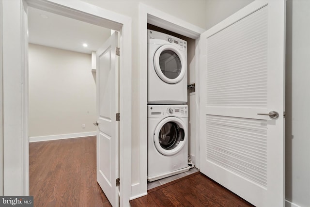 clothes washing area featuring stacked washer and clothes dryer and hardwood / wood-style flooring