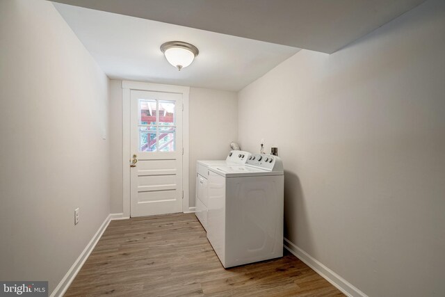 laundry room featuring washing machine and dryer and light hardwood / wood-style flooring