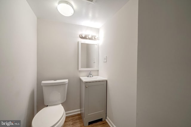 bathroom featuring vanity, wood-type flooring, and toilet