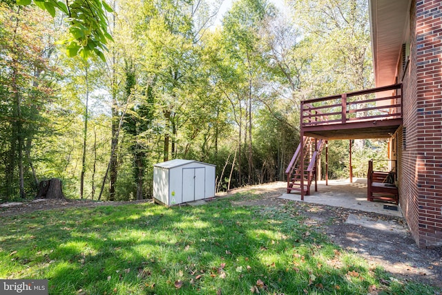 view of yard with a shed, a wooden deck, and a patio