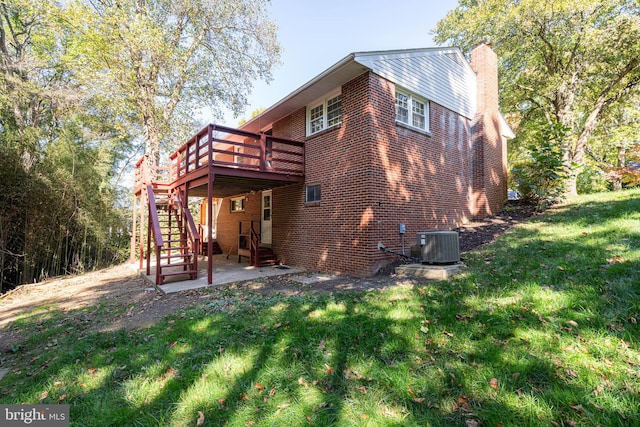 back of house featuring a wooden deck, central AC, and a yard