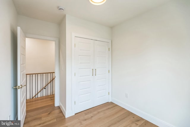 unfurnished bedroom featuring a closet and light wood-type flooring