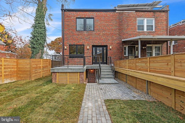 rear view of house featuring a lawn