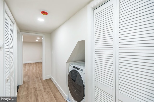 laundry area featuring washer / dryer and light hardwood / wood-style flooring