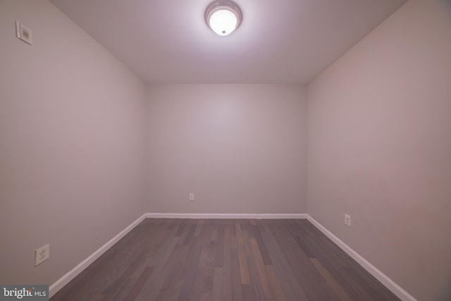 unfurnished room with dark wood-type flooring