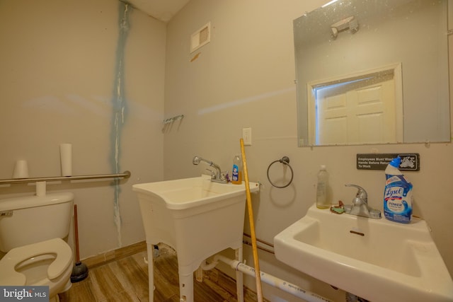 bathroom with hardwood / wood-style flooring, sink, and toilet