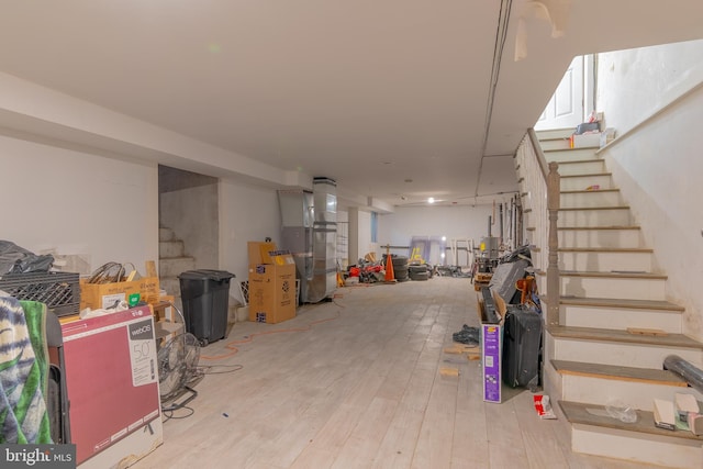 basement with heating unit and light wood-type flooring