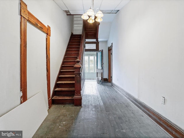 staircase with a chandelier and wood-type flooring