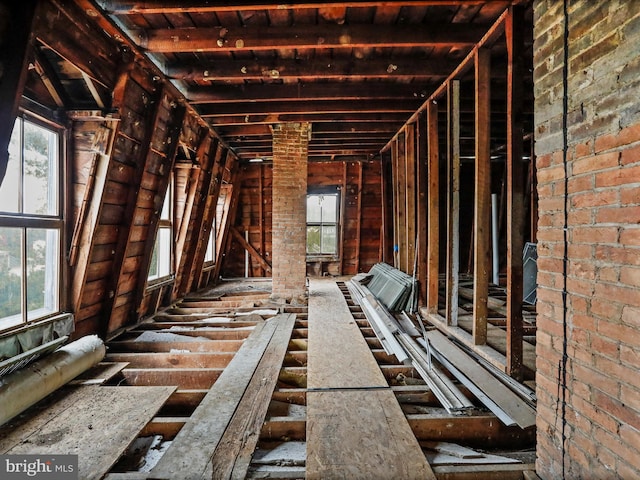 miscellaneous room with a healthy amount of sunlight and brick wall