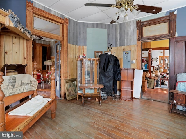 miscellaneous room featuring wood walls, wood-type flooring, and ceiling fan