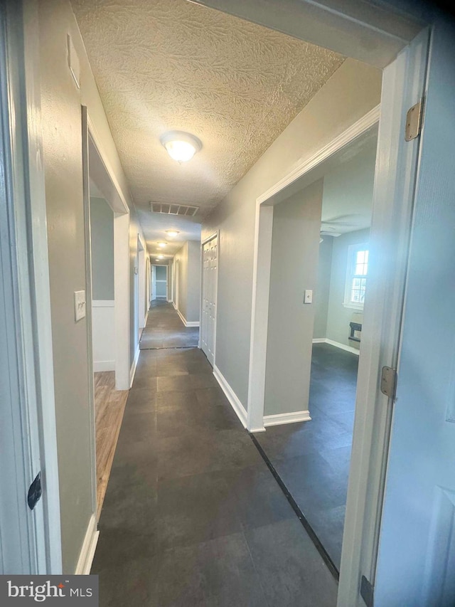 hall with a textured ceiling