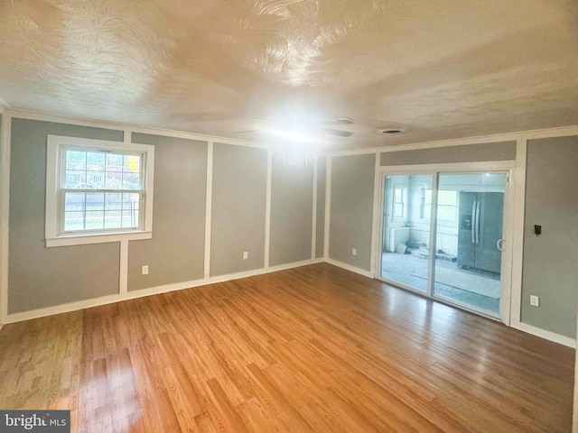 unfurnished room with hardwood / wood-style flooring and ornamental molding