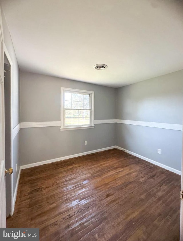 spare room featuring dark wood-type flooring