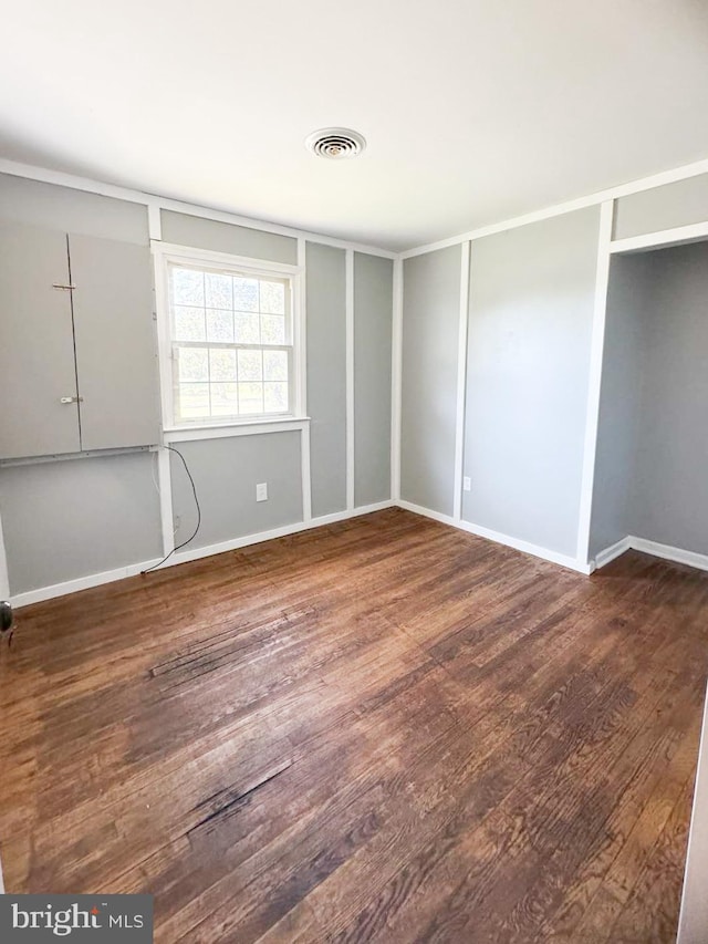 unfurnished bedroom with dark hardwood / wood-style flooring