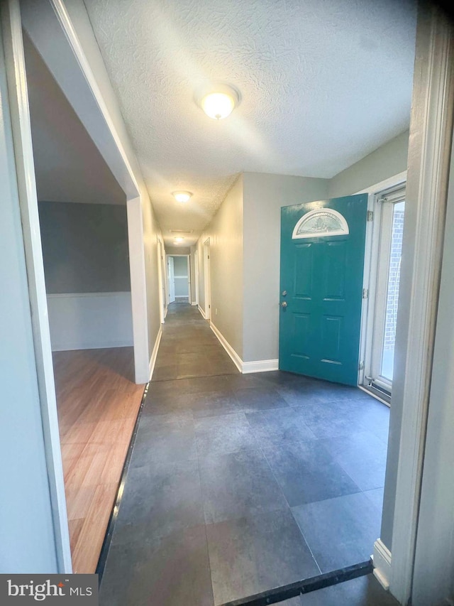 entrance foyer featuring a textured ceiling and dark hardwood / wood-style floors