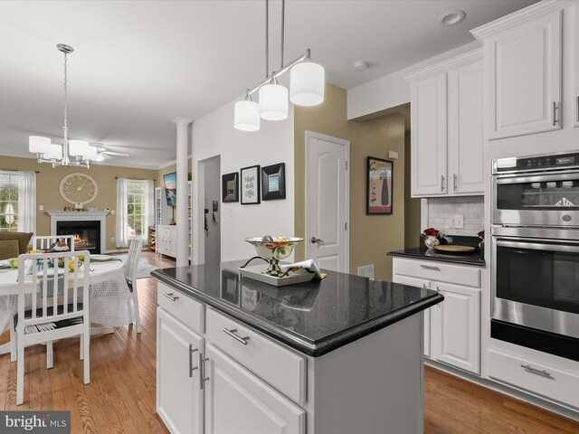 211 Glyndon Meadow Rd, Reisterstown, MD 21136 - kitchen featuring double oven, light wood-style floors, open floor plan, a center island, and white cabinetry