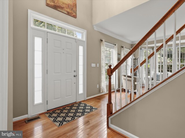 211 Glyndon Meadow Rd, Reisterstown, MD 21136 - entrance foyer featuring light wood-style flooring, baseboards, ornamental molding, and stairway