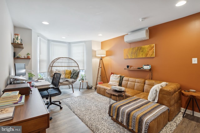 home office with light hardwood / wood-style floors and a wall mounted AC