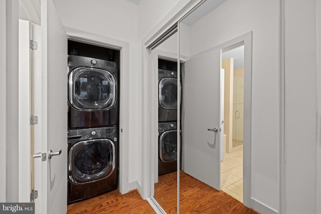 washroom featuring stacked washing maching and dryer and hardwood / wood-style floors