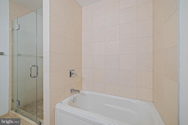 bathroom featuring shower with separate bathtub