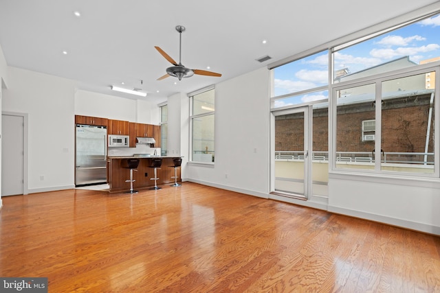 unfurnished living room featuring light hardwood / wood-style floors and ceiling fan