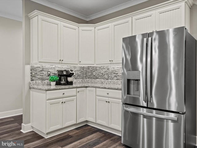 kitchen with stainless steel fridge, white cabinets, light stone counters, and ornamental molding