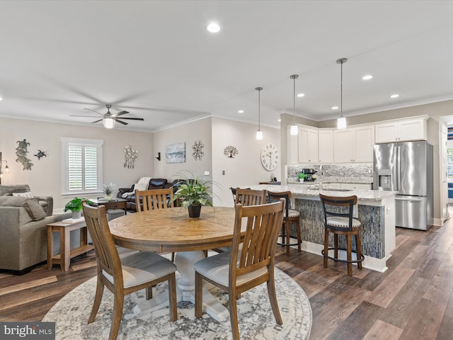 dining room with dark hardwood / wood-style floors, ceiling fan, and crown molding