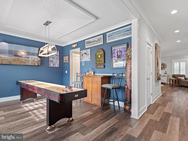 playroom featuring ornamental molding, dark wood-type flooring, and bar area