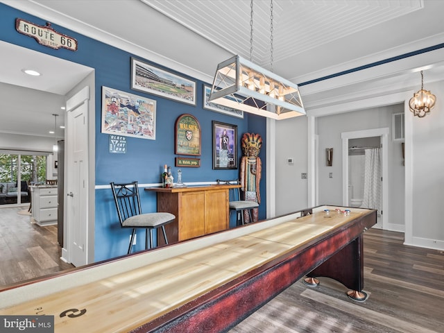 rec room featuring crown molding, dark wood-type flooring, and an inviting chandelier