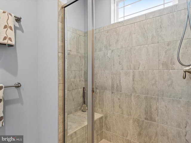 bathroom featuring a shower with shower door