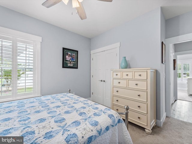 carpeted bedroom featuring a closet and ceiling fan