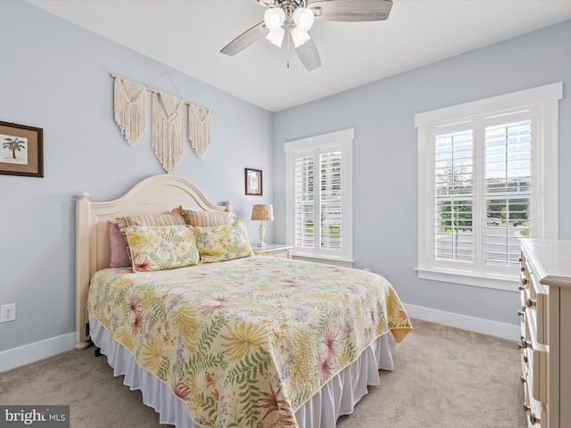 carpeted bedroom featuring ceiling fan and multiple windows