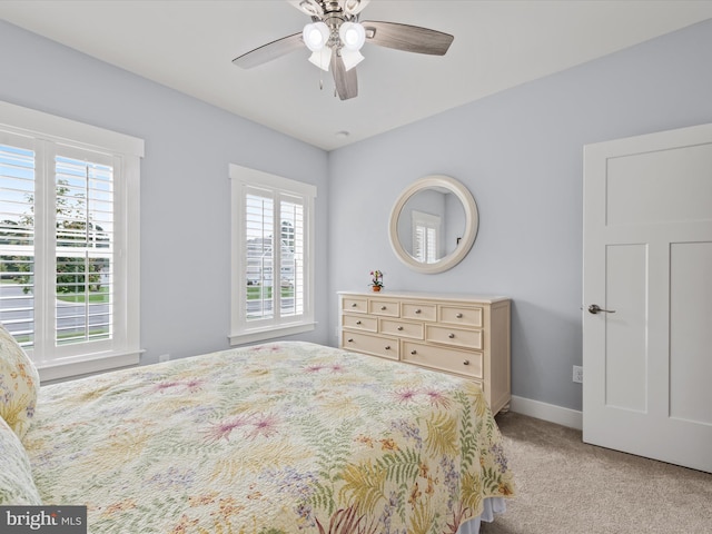 bedroom with ceiling fan, light carpet, and multiple windows