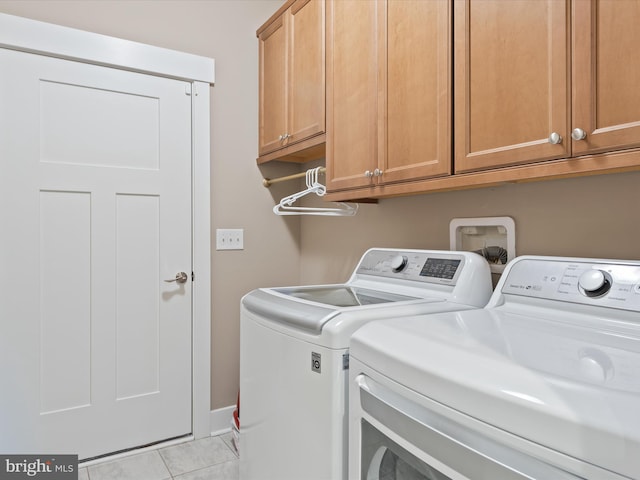 laundry area with cabinets, light tile patterned floors, and washing machine and dryer