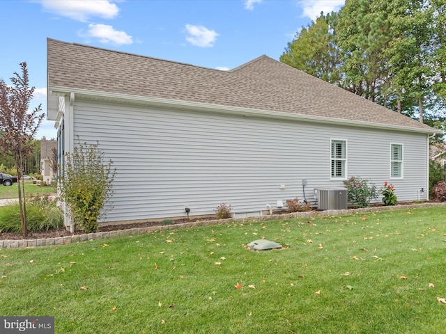 view of side of property featuring central air condition unit and a lawn