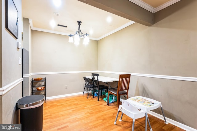 interior space featuring a chandelier, ornamental molding, wood finished floors, and baseboards