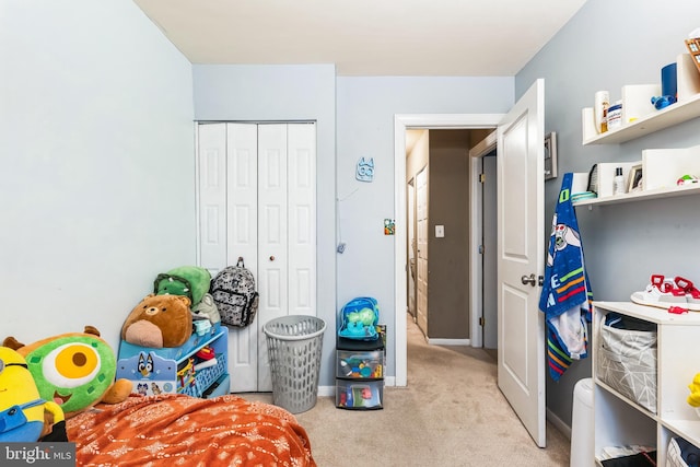 carpeted bedroom with a closet and baseboards