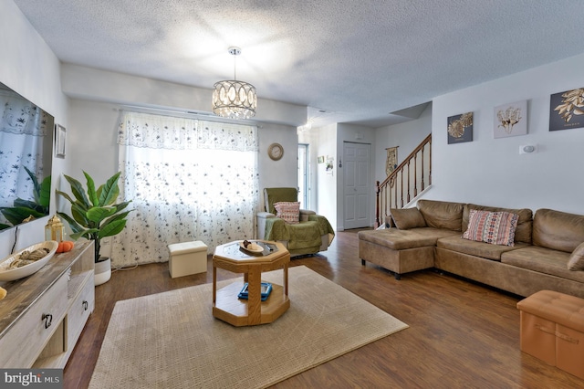 living room featuring dark hardwood / wood-style floors, a chandelier, and a textured ceiling