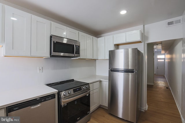 kitchen featuring white cabinets, stainless steel appliances, and dark hardwood / wood-style flooring