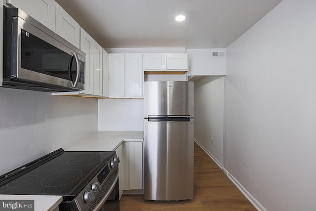 kitchen featuring appliances with stainless steel finishes, white cabinetry, and dark hardwood / wood-style flooring