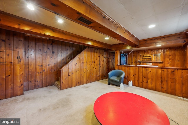 sitting room with wooden walls and carpet flooring